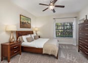 Thumbnail 19 of 22 - A bedroom with a bed, nightstand, and dresser.