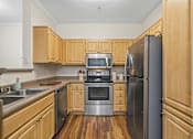 Thumbnail 19 of 30 - A kitchen with wooden cabinets and stainless steel appliances.
