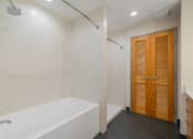 Thumbnail 21 of 36 - a bathroom with a tub and a shower and a wooden door