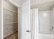 Thumbnail 20 of 22 - A white bathroom with a white tub and a white shower curtain.