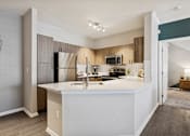 Thumbnail 20 of 30 - A kitchen with a white countertop and a refrigerator.