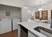 Thumbnail 21 of 28 - A modern kitchen with white appliances and a marble countertop.