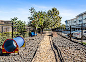 Thumbnail 22 of 32 - A playground with a blue slide and a red and yellow slide.
