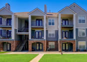 Thumbnail 24 of 25 - an exterior view of an apartment building with a lawn
