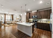 Thumbnail 25 of 32 - A modern kitchen with wooden cabinets and a white island.