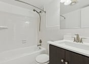 Thumbnail 27 of 28 - A white bathroom with a toilet, sink, and bathtub.