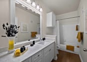 Thumbnail 27 of 28 - A bathroom with a white counter top and a white sink.