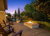 Thumbnail 30 of 30 - A fire pit in the middle of a patio surrounded by chairs.