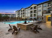 Thumbnail 30 of 30 - an outdoor pool with chairs and a fire pit at night