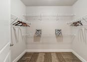 Thumbnail 32 of 32 - A white closet with two shelves and two hangers.