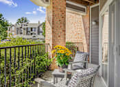 Thumbnail 30 of 31 - A balcony with a table and chairs overlooking a residential area.
