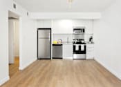 Thumbnail 4 of 29 - A kitchen with a refrigerator, oven, and microwave.