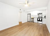 Thumbnail 5 of 29 - A kitchen with white walls and wooden floors.