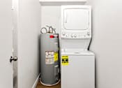 Thumbnail 13 of 29 - A water heater and a stove are in a small room.