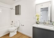Thumbnail 8 of 29 - A white toilet sits in a bathroom next to a sink.
