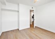 Thumbnail 12 of 29 - A white room with a sliding door and wooden flooring.