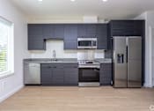 Thumbnail 6 of 25 - A modern kitchen with stainless steel appliances and dark grey cabinets. at Plisko Place, Port Orchard