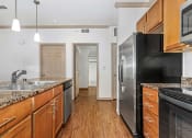 Thumbnail 29 of 30 - a kitchen with wooden cabinets and a stainless steel refrigerator