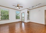 Thumbnail 28 of 30 - an empty living room with wood floors and a ceiling fan