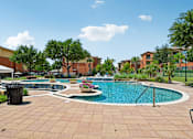 Thumbnail 22 of 64 - A pool surrounded by a brick patio and trees.