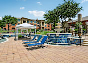 Thumbnail 20 of 64 - A pool area with a white canopy and blue lounge chairs.