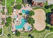 Thumbnail 2 of 64 - An aerial view of a park with a swimming pool and a sandy area.