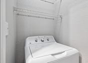 Thumbnail 61 of 64 - A white dryer is sitting in a small, white-walled laundry room.