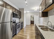 Thumbnail 41 of 45 - A modern kitchen with a stainless steel refrigerator and wooden cabinets.