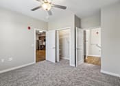 Thumbnail 44 of 45 - A room with a ceiling fan and carpeted floor.