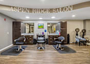 Thumbnail 13 of 45 - A salon with chairs and a counter with a sign that says "Aspen Ridge Salon".