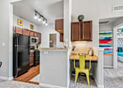 Thumbnail 32 of 64 - A kitchen with a black fridge and a yellow chair.