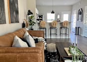 Thumbnail 1 of 9 - a living room with a brown couch and a wooden coffee table