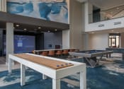 Thumbnail 20 of 75 - shuffleboard table, pool table, and foosball table in an entertainment room in front of a movie theater screen at The Apex at CityPlace, Overland Park, 66210