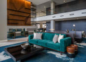 Thumbnail 22 of 75 - long, teal couch in front of a black, square coffee table in a large room at The Apex at CityPlace, Overland Park