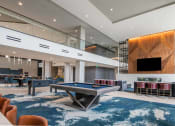 Thumbnail 19 of 75 - indoor entertainment room with a billiards table, foosball table, and chairs at The Apex at CityPlace, Overland Park, Kansas