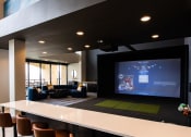 Thumbnail 17 of 75 - indoor movie theater screen with couches and barstools around a counter at The Apex at CityPlace, Overland Park, KS, 66210