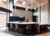 Thumbnail 55 of 75 - indoor bar with white counters at two hights and chairs around the countertop at The Apex at CityPlace, Overland Park, KS