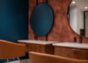 Thumbnail 27 of 75 - out of focus photo of chairs at desks with circular mirrors on the wall behind them at The Apex at CityPlace, Kansas