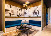Thumbnail 50 of 75 - blue corner booths with a black table and large paintings on the walls at The Apex at CityPlace, Overland Park, KS