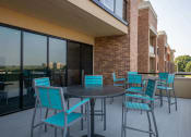 Thumbnail 23 of 75 - outdoor circular tables with blue chairs on a patio at The Apex at CityPlace, Overland Park