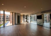 Thumbnail 46 of 75 - studio space with hardwood floors, ceiling to floor mirrors and windows, and some workout equipment at The Apex at CityPlace, Overland Park, KS