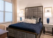 Thumbnail 34 of 75 - a bed with blue comforter in a bedroom with two lamps and a large window at The Apex at CityPlace, Overland Park, 66210