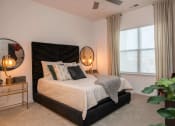 Thumbnail 37 of 75 - bedroom with a large window, two nightstands with mirrors, and a bed with white comforter at The Apex at CityPlace, Overland Park, Kansas