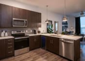 Thumbnail 30 of 75 - kitchen with brown cabinets and stainless steel appliances at The Apex at CityPlace, Kansas, 66210