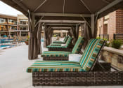 Thumbnail 7 of 75 - chaise lounge chairs in a row under a canopy next to an outdoor pool  at The Apex at CityPlace, Overland Park, Kansas