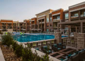 Thumbnail 56 of 75 - view of outdoor pool and lounge area with chairs surrounded by apartment complex buildings at The Apex at CityPlace, Overland Park, KS, 66210