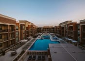 Thumbnail 59 of 75 - view of u shaped apartment complex with an outdoor pool in the center and rows of seating on the patio at The Apex at CityPlace, Kansas