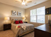 Thumbnail 6 of 34 - A furnished bedroom with a ceiling fan and a window at Aspen Ridge 55+ Apartment Community in Olathe, KS
