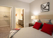 Thumbnail 7 of 34 - A furnished bedroom with a full bathroom and walk-in closet at Aspen Ridge 55+ Apartment Community in Olathe, KS