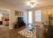 Thumbnail 10 of 34 - A furnished living room with a ceiling fan and patio access in a 2-bedroom apartment at Aspen Ridge 55+ Apartment Community.